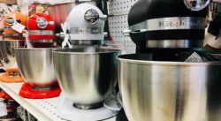 Display of KitchenAid mixers in a row - different colors.